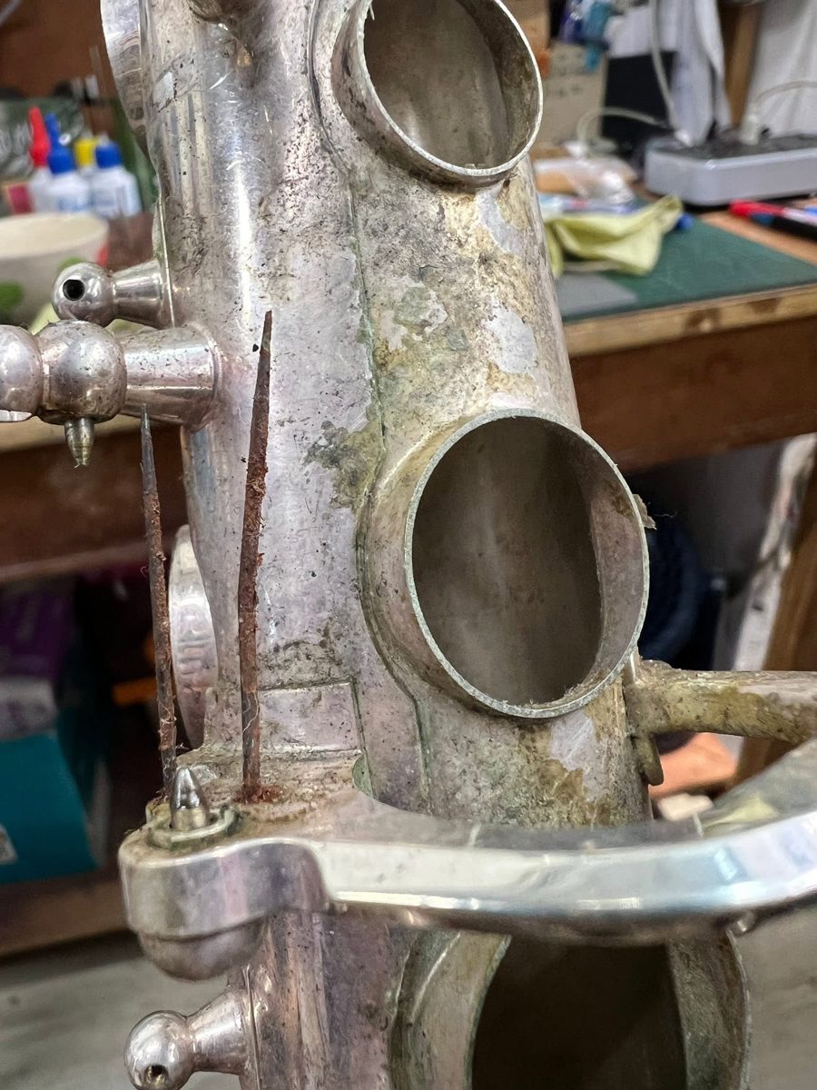 Silver-plated saxophone with tarnish and corrosion around the tone holes