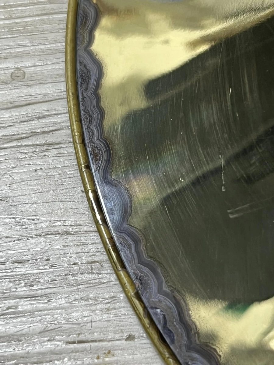 Brass bell rim with tarnish and lacquer breakdown